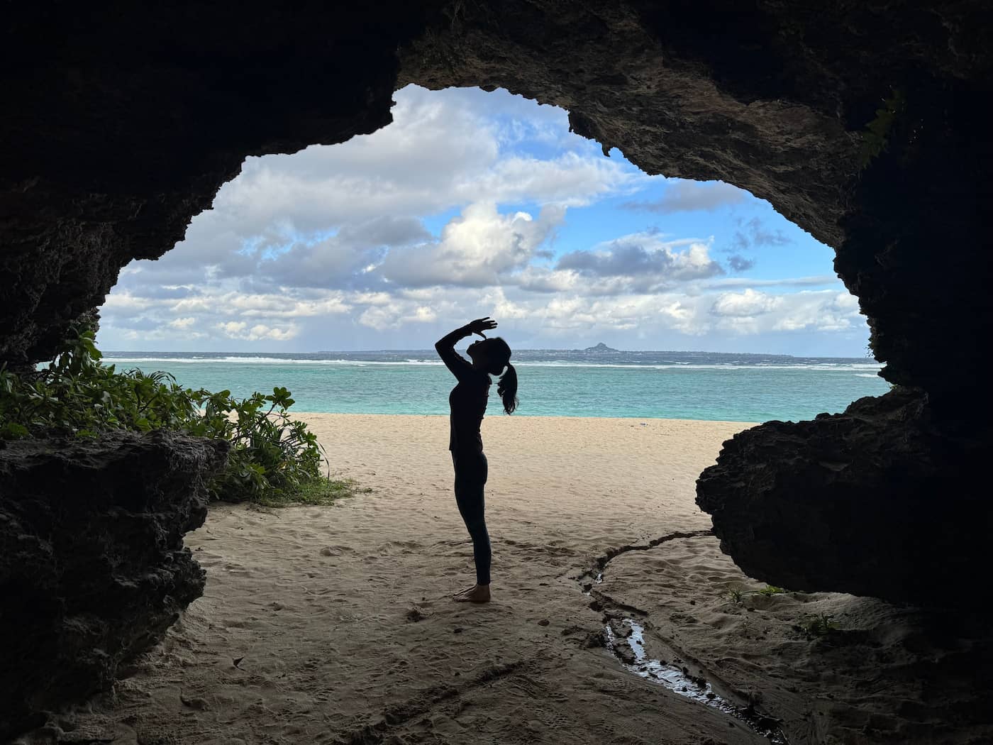 洞窟から海を眺めるヨガのシルエット