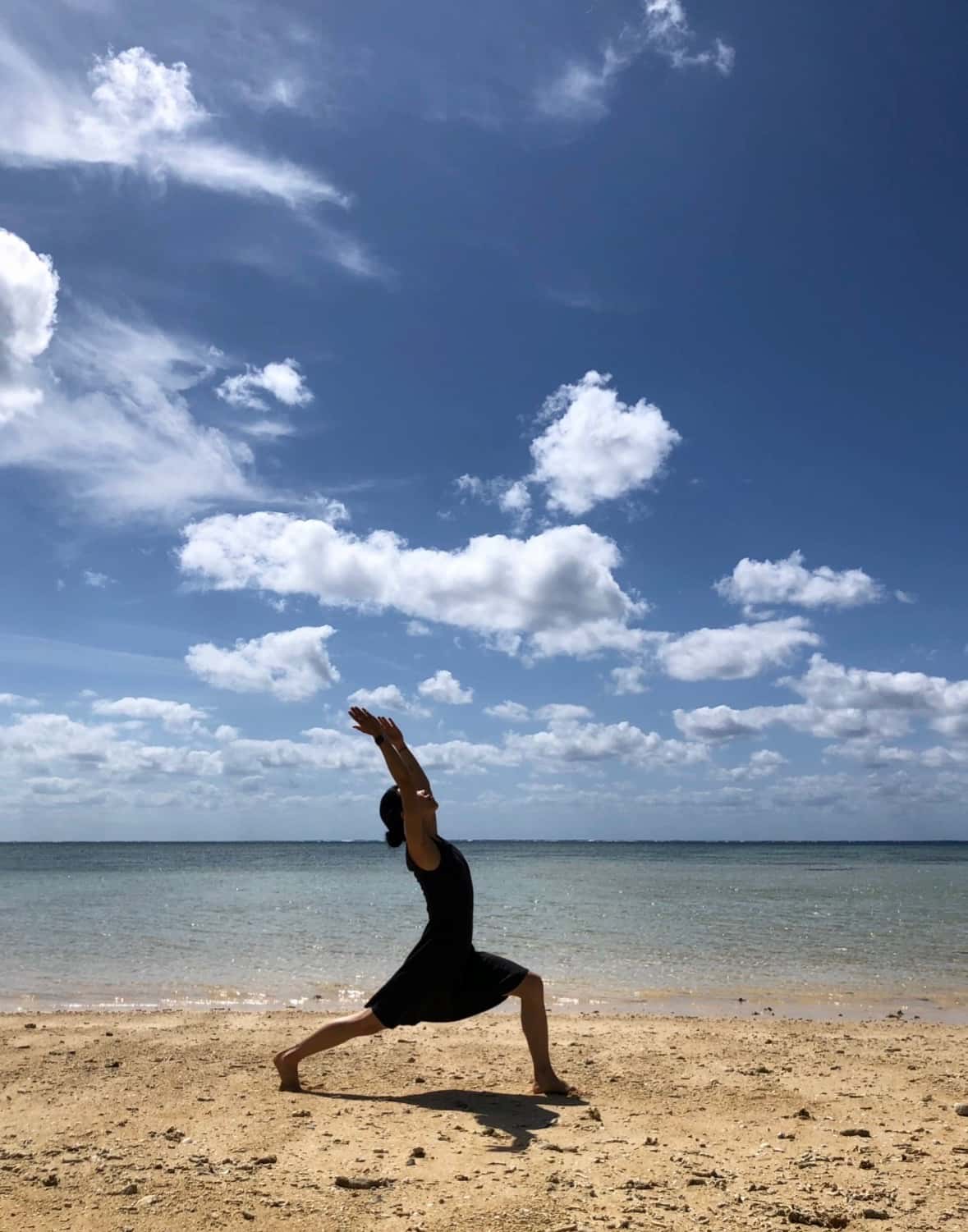 海辺でポーズをとるヨガ講師